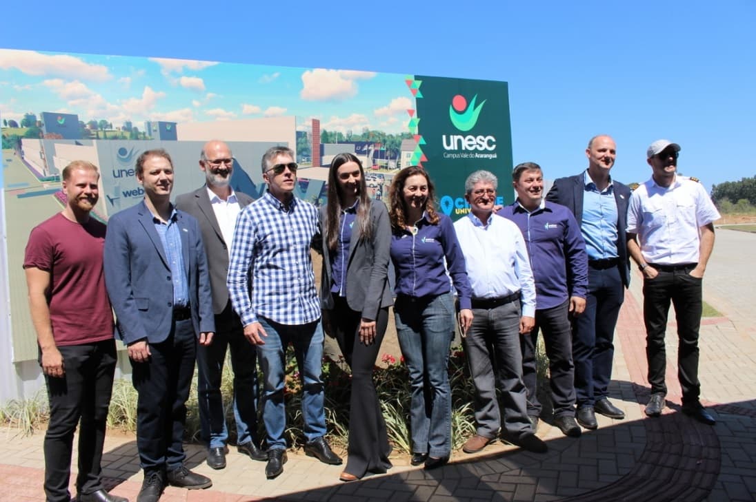 Diretor da TV Unisul posa para foto, comemorando construção de universidade concorrente em Araranguá