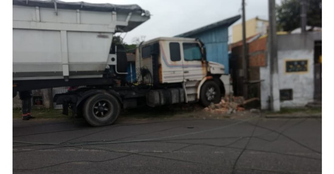 Caminhão desce avenida desgovernado, arranca poste e bate em muro