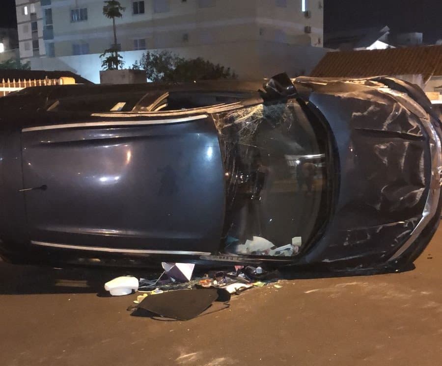 Carro capota após colisão com veículo estacionado, em Laguna