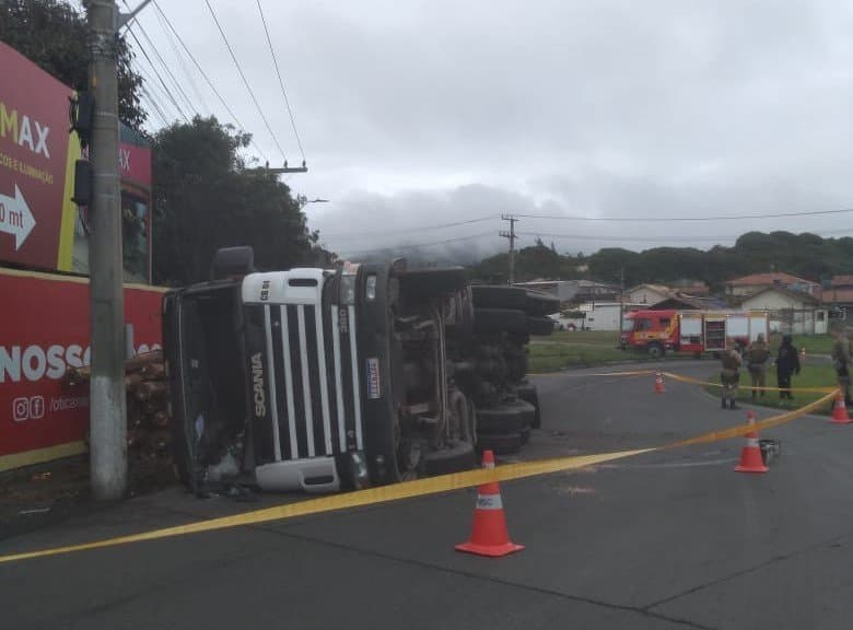 Carreta carregada de madeira tomba e vazamento de combustível precisa ser contido