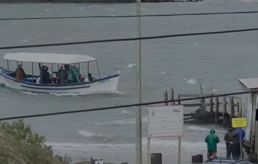 Bote quase não consegue atravessar canal da barra, em Laguna, por causa dos fortes ventos